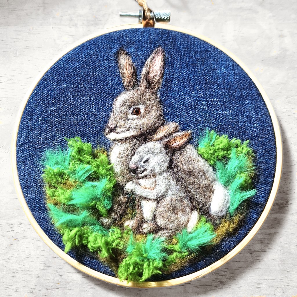 Needle-felted bunnies in woolly grass